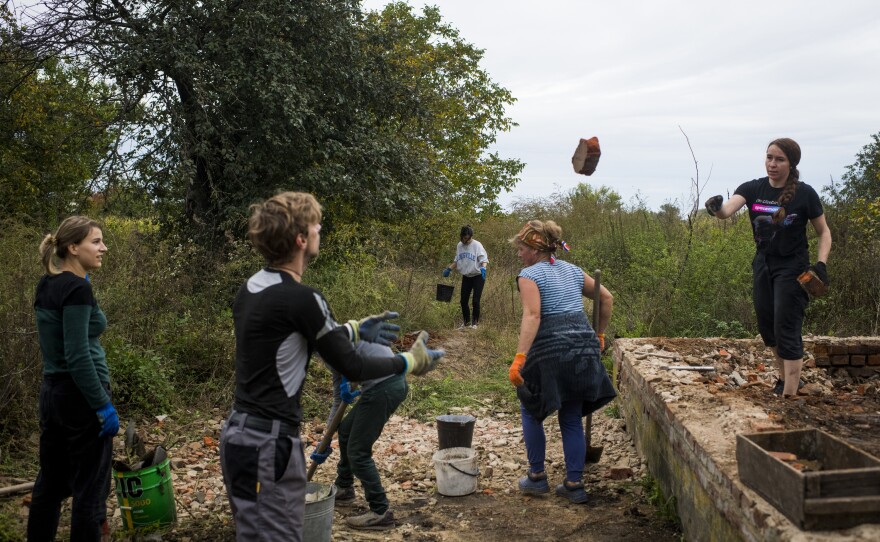 Volunteers from Repair Together work at the destroyed home of the Vereshchahina family in Kolychivka on Oct. 1.