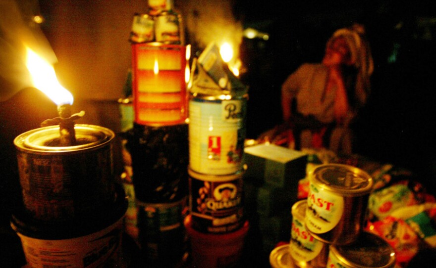 <p>A street vendor sells her wares by the light of a kerosene wick lamp in Lagos, Nigeria. The country claims ownership of one of the world's great energy reserves, but corruption and mismanagement leave Africa's oil giant chronically short of electricity. Businesses and walled residential compounds run costly diesel generators. </p>