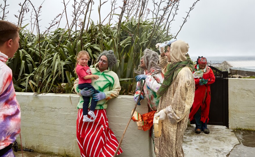 After removing his mask to reveal himself, Julian Repetto holds and comforts his daughter, Makayla. When this did not calm the little girl, the other Okalolies followed suit. The Okalolies are careful not to frighten children and the elderly too much. Some islanders, however, are genuinely afraid and will lock themselves inside their houses.