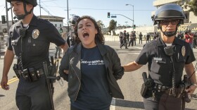 High school student Claudia Rueda, 17, center, is arrested by Los Angeles Police officers for failing to disperse, as protestors blocked the intersection of the Los Angeles Sheriff's Department Twin Tower Correctional Facility in Los Angeles Thursday, Sept. 6, 2012.