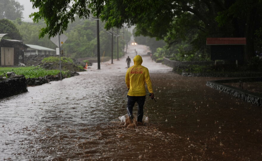 Fire Captain Lui Sales of the Hawaii Fire Department looks for residents to help as rainwater from nearby Hurricane Nolo flood a section of Mamalahoa highway Saturday, Sept. 26, 2026, near Naalehu, Hawaii.