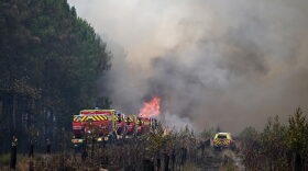 Firefighters tackle a blaze as wildfires rage near Le Las, outside Bordeaux, France, Monday, July 27, 2026.