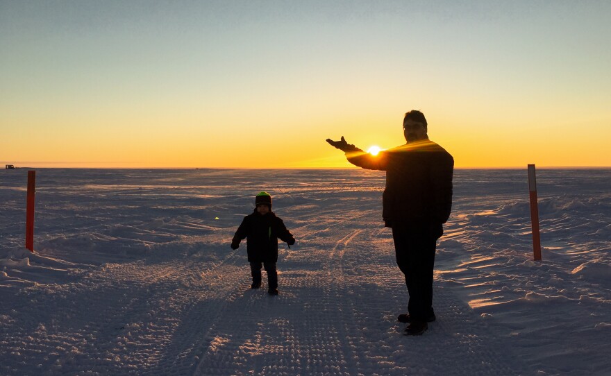Robin Mongoyak and his young son enjoy the sunshine out on the southern edge of Utqiaġvik.