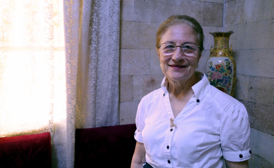 Denise Khoury, standing inside the Church of the Sacred Heart of Jesus in Latakia, says she checked on her mother's home in northern Syria after the war and found it occupied by foreign fighters.