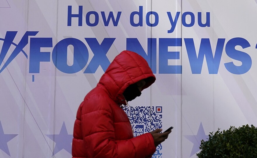 A person walks past the Fox News headquarters at the News Corporation building in New York City last month. Dominion Voting Systems is suing Fox News and parent company Fox Corp. over election fraud claims that Fox aired in 2020 and 2021.