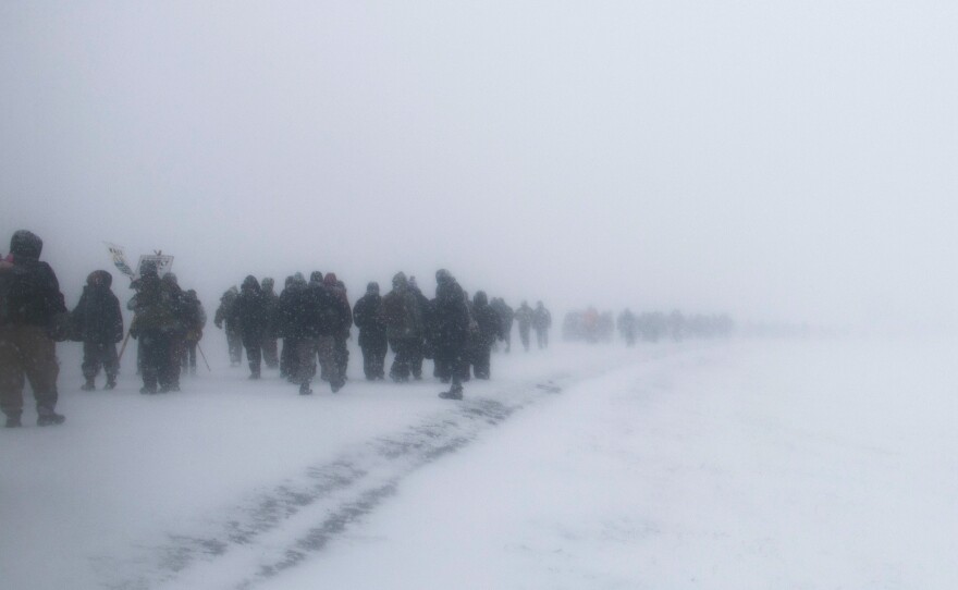 Water protectors and veterans march to the front lines at Backwater Bridge on Monday after the announcement that the U.S. Army Corps of Engineers will not approve an easement for the final and key part of the controversial Dakota Access Pipeline.