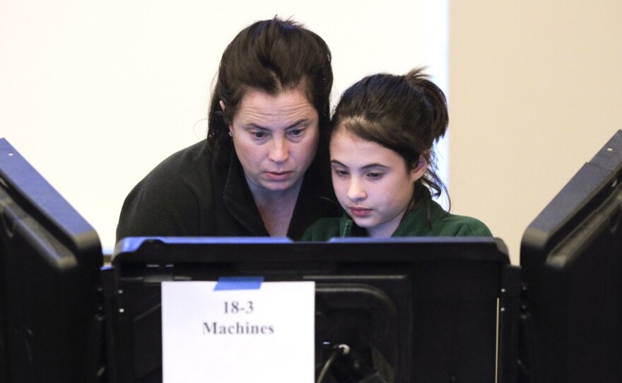 Sally Tepper, 12, watches her mother, Dana, vote in Nashville, Tenn., on Tuesday. Pew experts say Romney trails Obama among women, 38 to 59 percent.