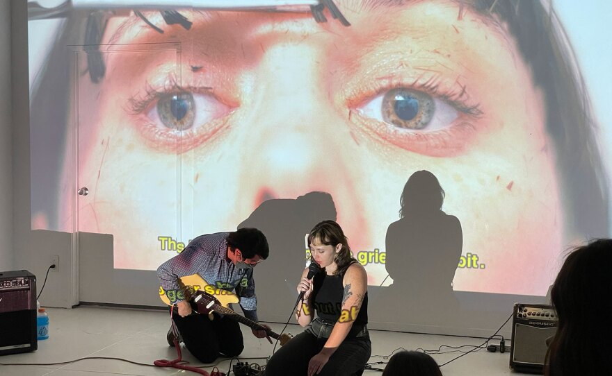 Poet Lora Mathis and musician Matty Terrones perform against a projected backdrop of Mathis' visual poetry and film stills on Sept. 17, 2021.