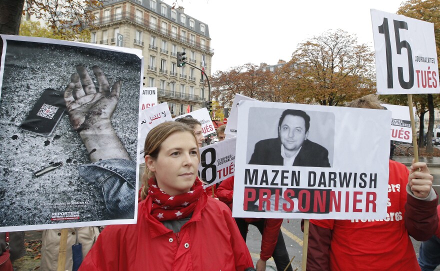 Lucie Morillon, head of research at French watchdog of Reporters Sans Frontieres (Reporters without Borders) holds a banner depicting Syrian human rights activist Mazen Darwish during a protest against violence in Syria, in Paris, Saturday, Oct. 20, 2012. Darwish was released from a Syrian prison Monday.