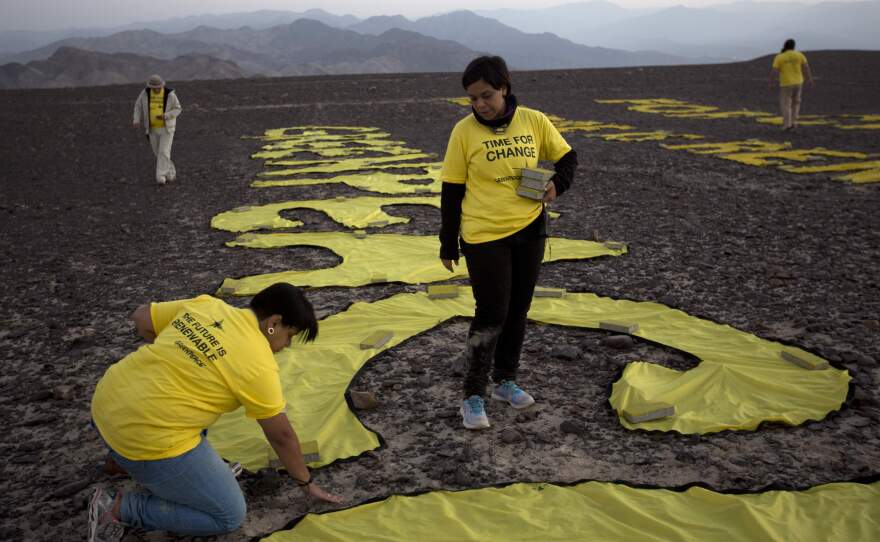 Greenpeace activists arrange the letters next to the hummingbird geoglyph in Nazca, Peru. Greenpeace apologized for the protest Wednesday, saying they came across as careless and crass.