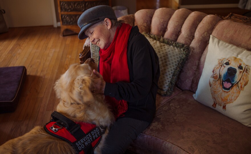 Peggy Gibson sits in her living room with her service dog, Rocky, in West Jefferson, N.C., last November. Gibson says Rocky, a diabetic alert dog, isn't able to work well in public.