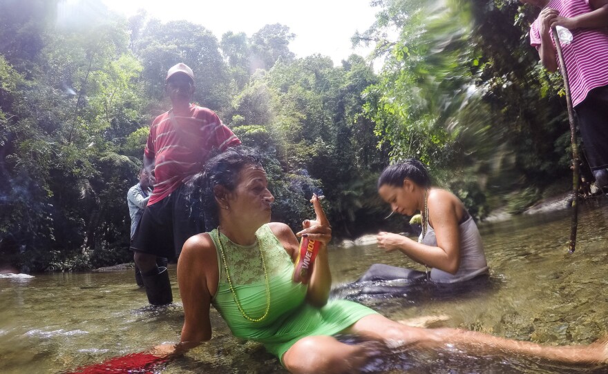 Marta Amaro and Liset Barrios take a minute to rest after crossing a river in the Darien Gap, the untamed jungle that engulfs the Colombia-Panama border. Photographer Lisette Poole went with them to document their journey north.