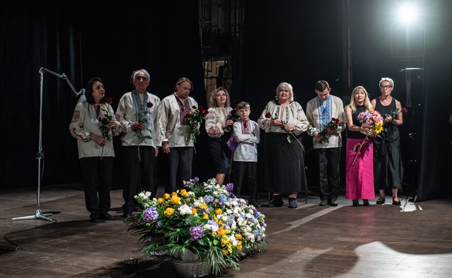 The cast members of the play "Cry of a Nation" stand before the audience after the premiere at the Uzhhorod municipal theatre on July 16, 2022.