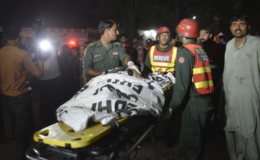 Rescuers use a stretcher to shift a body from a bomb blast site in Lahore, Pakistan, on Sunday.