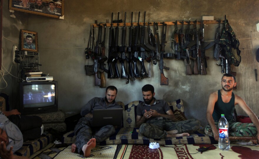 Free Syrian Army fighters sit in a house on the outskirts of Aleppo, Syria, in June 2012. The U.S. is planning to train and arm the rebels, who have been outgunned on the battlefield.