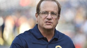 Dean Spanos talks on the field before an NFL pre-season football game between the San Diego Chargers and the Dallas Cowboys, Aug. 7, 2014.