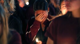 A woman cries during a candlelight vigil for the victims of the Wednesday shooting at Marjory Stoneman Douglas High School, in Parkland, Fla., Thursday, Feb. 15, 2018.