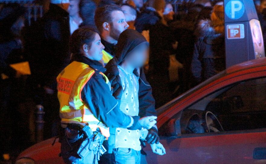 Police detain a man as people gather in front of the main railway station in Cologne on Jan. 1. Police in Cologne told AFP they have received more than 100 complaints by women reporting assaults ranging from groping to rape, allegedly committed in a large crowd of revelers during year-end festivities outside the city's main train station and its famed Gothic cathedral.
