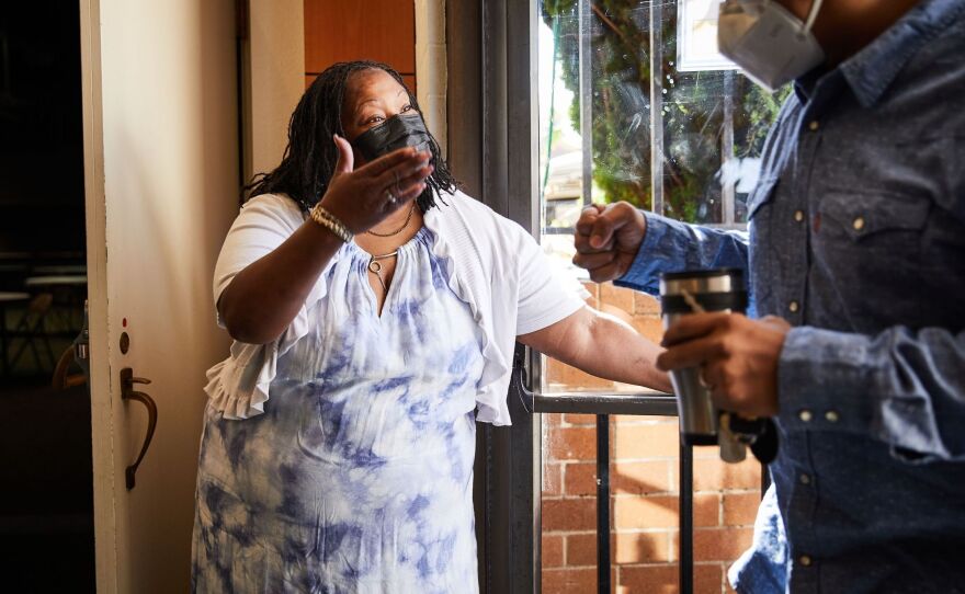 Community health worker Teresa Johnson greets Pastor Shon Neyland before Sunday church services. Highland Christian Church estimates about half of its congregation is still not vaccinated.