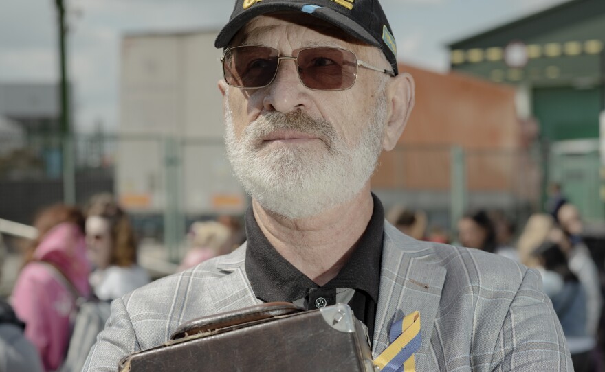 Yuri Vasylevych, 71, waits with his saxophone at the Poland-Ukraine border to cross to the Ukrainian side.