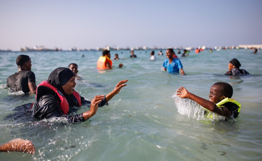 A mother and her son play in the sea at Liido Beach in Mogadishu, Somalia. Despite decades of conflict and ongoing security threats, some Somalis are carving out a middle-class lifestyle in the Somali capital.