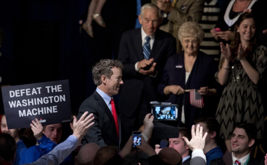 Ron Paul looks on as Rand, a Kentucky senator, arrives for the announcement of his presidential campaign.