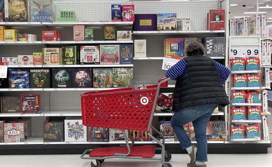 A Target customer looks at a display of board games while shopping at Target store in San Francisco, Calif. Inflation continues to ease, even if many people many not feel that way in their daily lives.