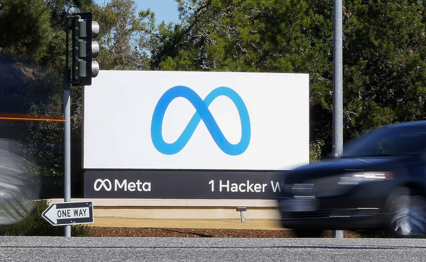 A car passes Facebook's new Meta logo on a sign at the company headquarters in Menlo Park, Calif.