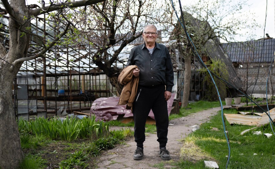 Yuriy Tostopalov stands outside his home in Moshchun.