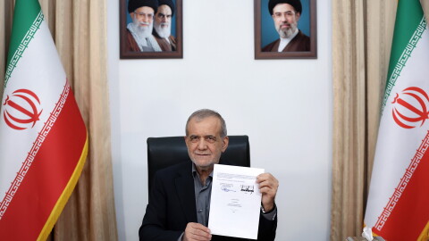 In this photo provided by the Islamic Republic News Agency (IRNA), Iranian President Masoud Pezeshkian displays a memorandum of understanding signed with U.S. President Trump aimed at ending the war and launching negotiations on a broader agreement, in Tehran, Iran, early Thursday.