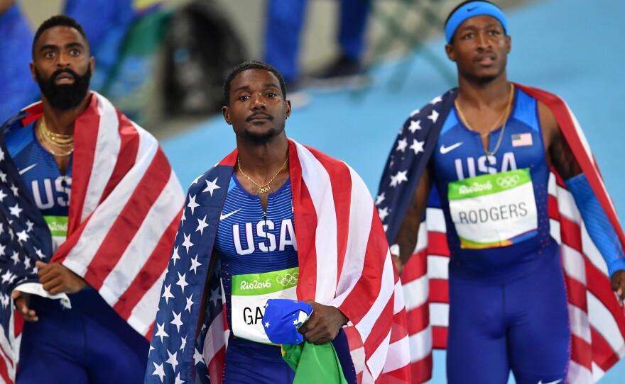 Men's 4x100m relay teammates Tyson Gay, Justin Gatlin and Michael Rodgers react after being disqualified from the race at the Olympic Stadium in Rio de Janeiro Friday.