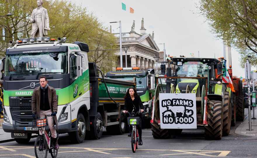 Cyclists ride past tractors blocking O'Connell Street on the fifth day of the National Fuel Protest, in Dublin, Ireland, on Saturday.