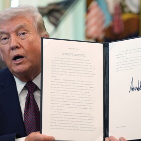 President Trump holds his signed executive order that calls for restricting voting by mail in the White House's Oval Office in March.