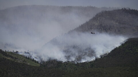 A helicopter drops water on the Cottonwood Fire in Beaver, Utah, on Saturday, June 27, 2026.