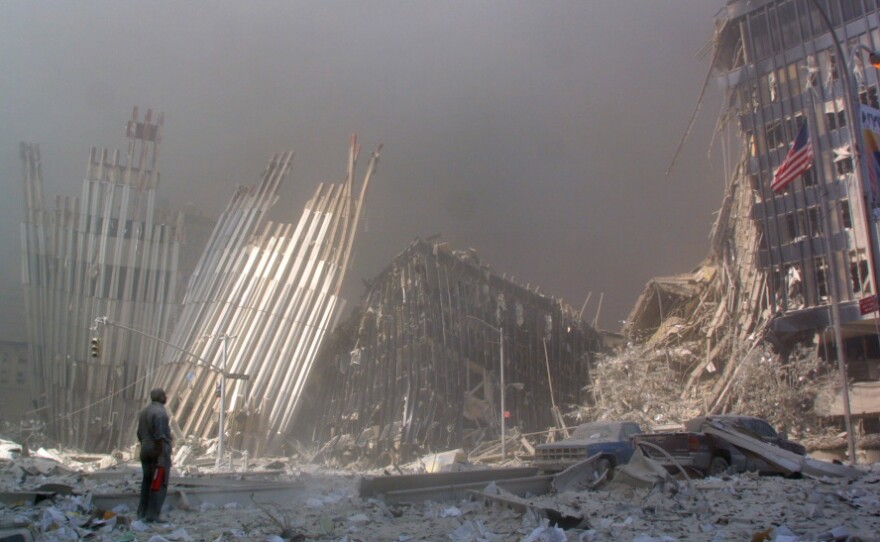 A man standing in rubble shouts to see if anyone needs help after the collapse of the first World Trade Center Tower in New York on Sept. 11, 2001.
