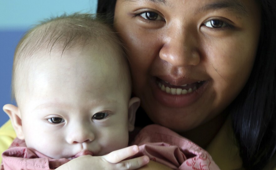 Thai surrogate mother Pattaramon Chanbua, poses last August with Gammy, then nine months old. The boy, who has Down Syndrome, was rejected by the Australian couple who contracted Pattaramon for the birth.