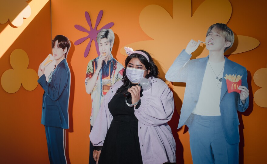 Abi Castaneda, 25, stands with McDonald's cutouts of BTS members V, RM and J-Hope.