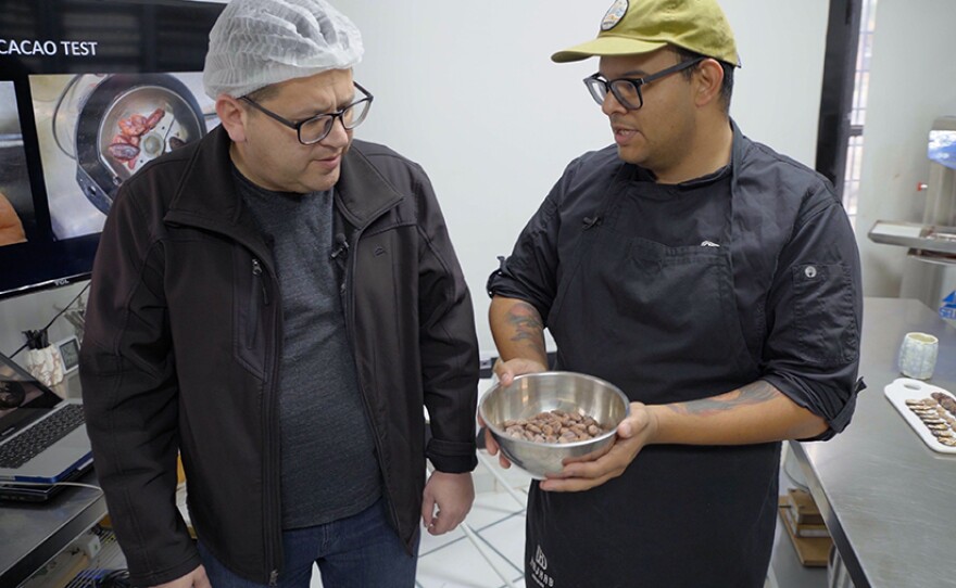 Host Jorge Meraz (left) learns about cocoa beans at the Kajkab Chocolate Factory tour in Tecate, Baja Calif.