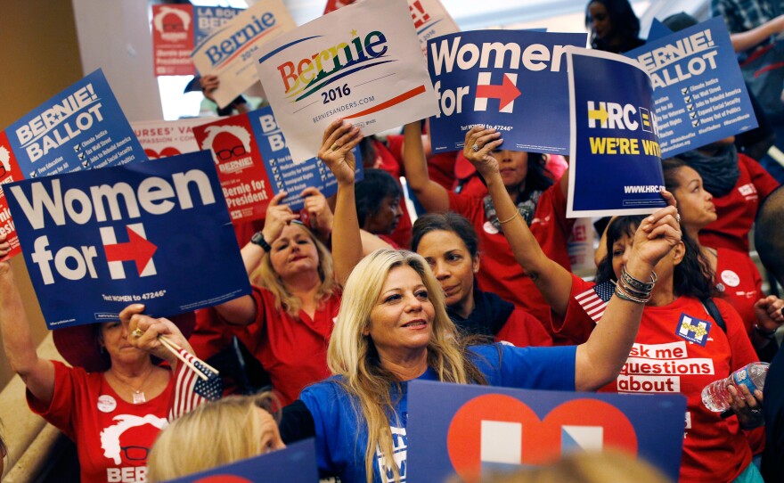 Supporters of Hillary Clinton and Bernie Sanders cheer on their presidential candidates before entering a caucus site in Las Vegas.
