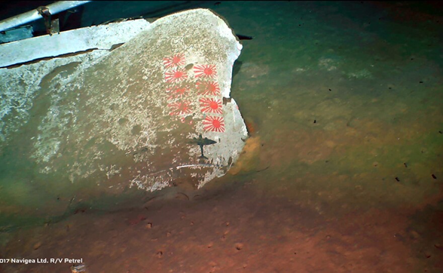 A portion of the starboard wing of the USS Indianapolis on which the ship’s crew painted her scorecard, which records the number and types of enemy war materiel the crew destroyed in combat. The nine Japanese flags indicate the number of aircraft shot down by the ship.