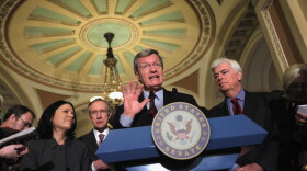Senate Finance Chairman Max Baucus (D-MT) (C) speaks to reporters about health care reform, flanked by Senate Majority Leader Harry Reid (D-NV), (L), and Senate Banking Chairman Chris Dodd (D-CT), (R), following a Democratic senatorial luncheon at the Capitol October 20, 2009 in Washington, DC. 