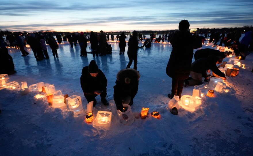 Activists gather in protest to light candles on frozen Lake Nokomis in Minneapolis, spelling, "Ice Out" on Jan. 31, 2026.