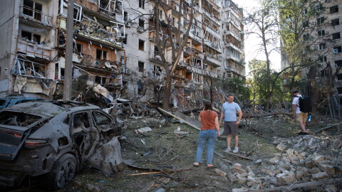 People look at a residential building damaged during the Russian missile attack in Kyiv, Ukraine, Thursday.