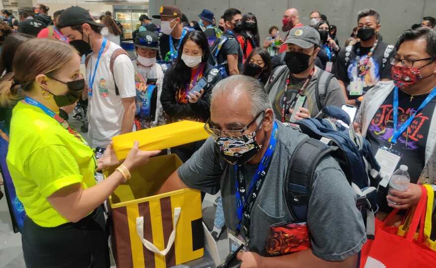 Comic-Con attendees inside the Exhibit Hall get free pins from Toynk, July 24, 2022.