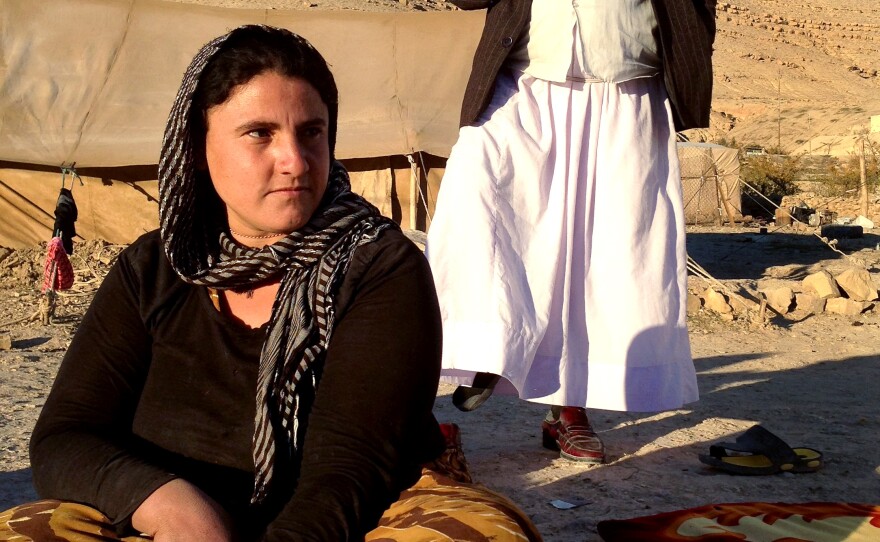 Sevi Zendi, from Iraq's Yazidi minority, says her family sleeps with guns in their tent in case ISIS reaches the exposed encampment. Standing behind her is family patriarch Abdi Ismail, who says that his whole family accepted the decision to stay on Mount Sinjar, passing up the opportunity to escape the ISIS siege when a path was opened.