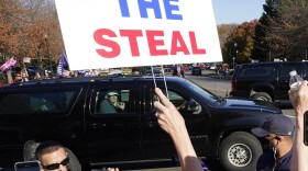 President Donald Trump looks on to supporters after leaving the Trump National golf club in Sterling, Va., Saturday, Nov 7, 2020. 