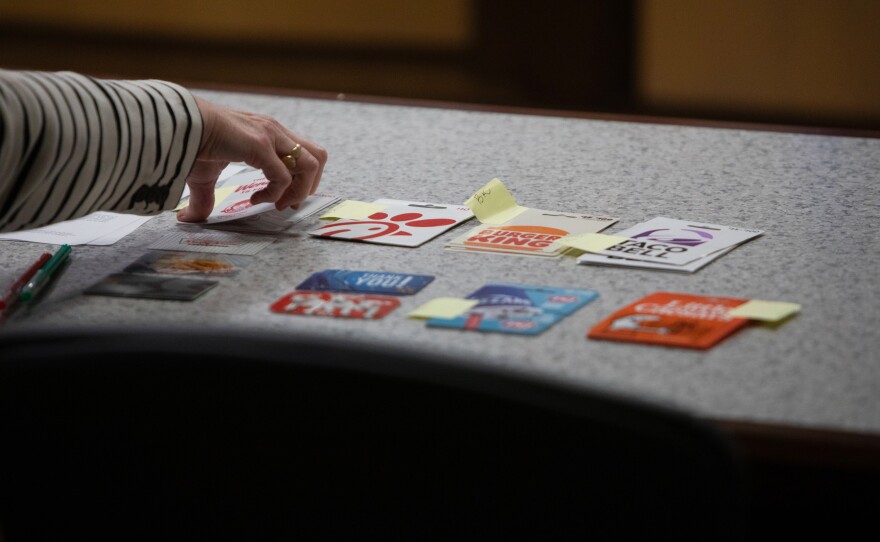 An assistant to Judge Sunny Bailey hands a young adult attending DAAY court a gift card to them for their good behavior.