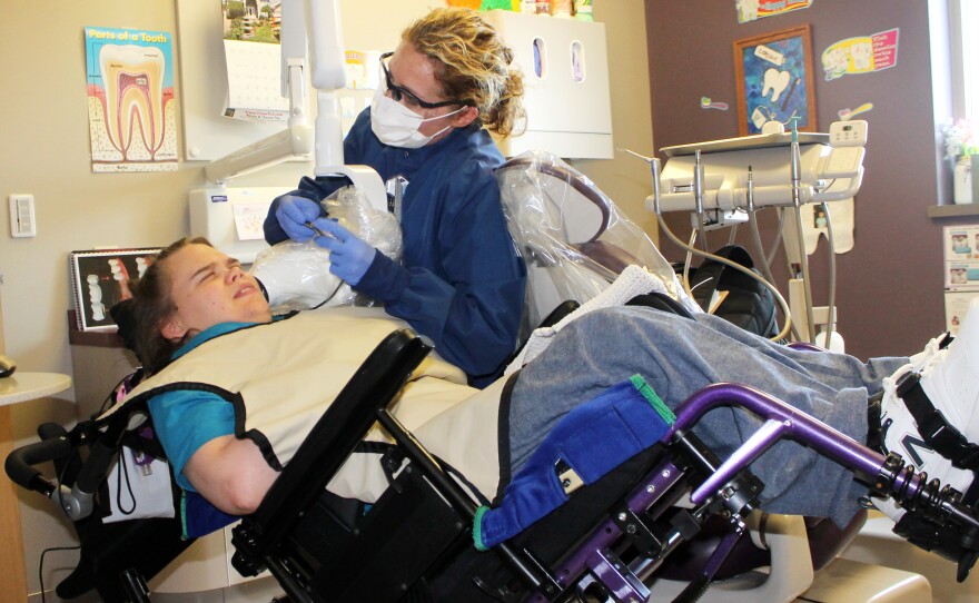 Beth Rown (right), a dental hygenist who cares for patients with special needs, cleans Lindsay Klecker's teeth.
