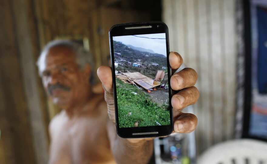 José Ramón Sierra Meléndez, 70, shows a photo of his destroyed house after Hurricane Maria.