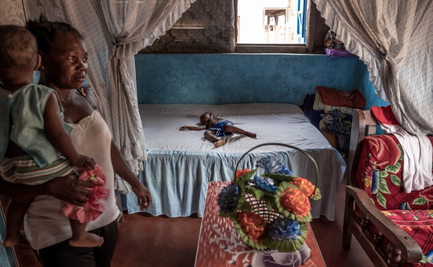 A boy sleeps in a large bed in the spacious home of a successful vanilla farmer in Belambo, Madagascar.